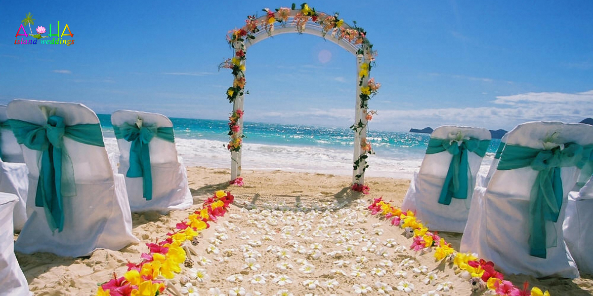 turquiose sash with sparkling waters of Bellows beach with white flowers of plumerias on the sand